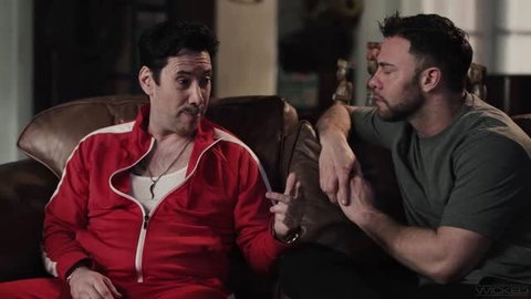 Melissa Staton in red tracksuit with man on leather couch