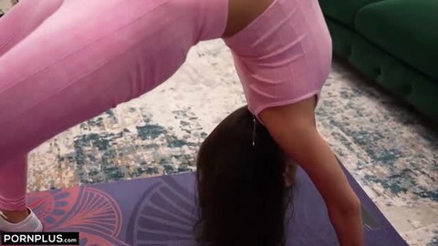 Sasha Tatcha in pink yoga pants performing flexible upside down stretch on mat