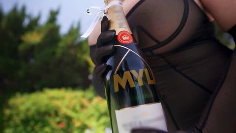 Sarah Arabic in sheer black lingerie holding MYLF champagne bottle