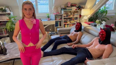 Emily Belle wearing pink top and pants with two masked men on couch