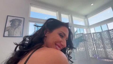 Smiling brunette OnlyFans model in black top selfie