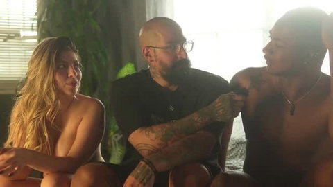 Blonde woman and two tattooed men in intimate threesome scene
