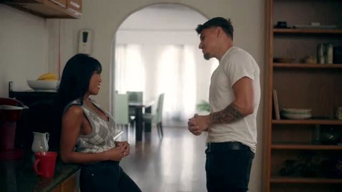 Ember Snow in tight tank top smiling at muscular man in kitchen