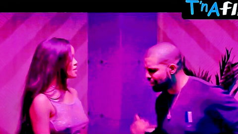 Rihanna in sexy sheer dress scene with bald man in purple lit room