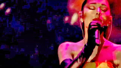Brunette singer passionately deepthroating microphone with glossy lips in sexy performance