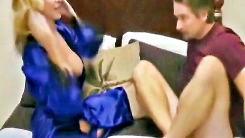 Blonde MILF in blue satin robe with man on couch in Mom Support scene