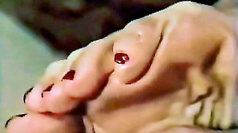 Close-up of mature white BBW woman's bare foot with red toenails