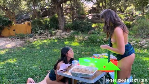 Two topless brunettes at outdoor picnic table with FreeUse Fantasy branding