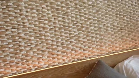 Sasha Rose close-up of textured wall and wooden bed frame