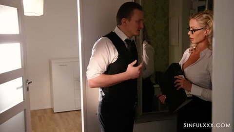 Miss Sally in glasses and white blouse with suited man in office doorway