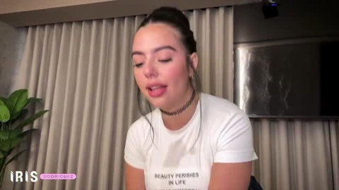Iris Rodriguez in white t-shirt, choker, long brunette hair