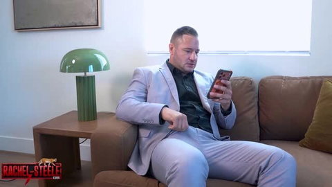 Suit-wearing man checking phone on couch, Best Friend’s Hot Mom thumbnail