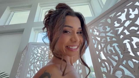 Ava Amira smiling topless with Dredd's BBC tattoo visible