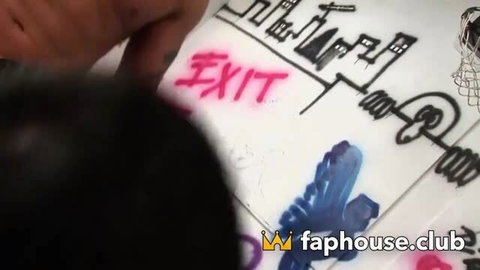 Close-up of EXIT graffiti in pink on tiled wall