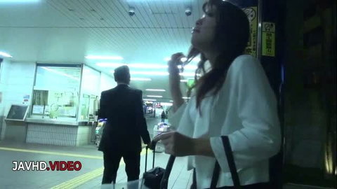 Shiona Suzumori in white office blouse waiting at train station
