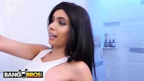 Aaliyah Hadid in white dress, dark hair, looking back over shoulder