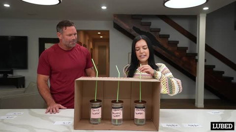 Brunette in sweater sucking straw in blind taste test with man