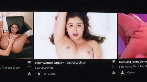 Leana Lovings topless with large natural breasts in white sheets, mouth open in pleasure