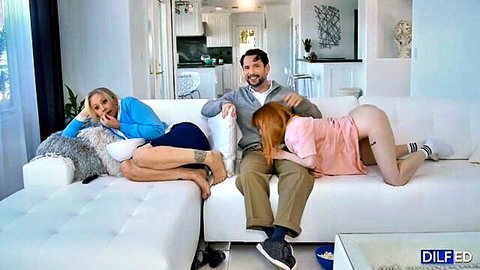 Petite redhead teen bent over doggystyle on couch exposing shaved pussy and small ass to smiling DILF while blonde MILF laughs