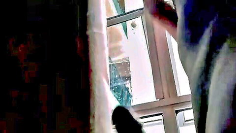 Young Brazilian woman looking out window seductively