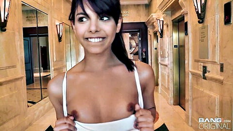 Sexy Latina babe flashing perky tits in white tank top, smiling seductively