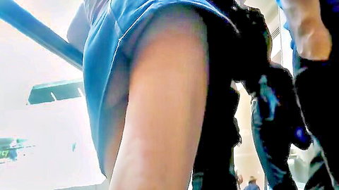 Upskirt view of woman in blue skirt on escalator, public tease