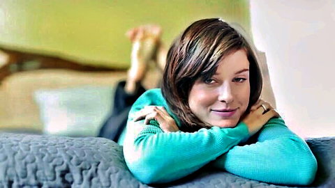 Zoey lounging seductively in teal sweater, bare feet visible