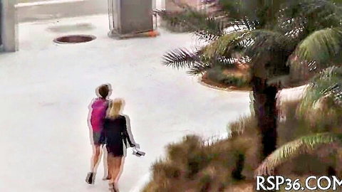 Two teens in shorts and dress walking outdoors on rooftop
