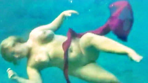 Blonde woman topless underwater swim in red skirt, nude teasing