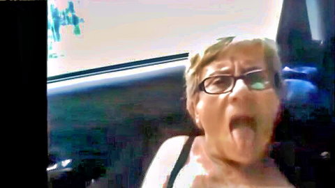 Granny with glasses sticks out wet tongue teasingly in car amateur POV
