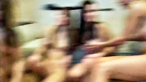 Blurry gangbang with busty brunettes sucking cocks and huge tits bouncing during wild fuck.