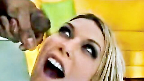 Blonde babe with wide open mouth stares at huge black cock held by strong hand closeup