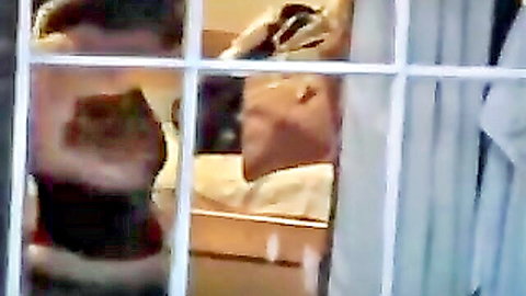 Voyeur peeking through window at nude woman's exposed ass on bed