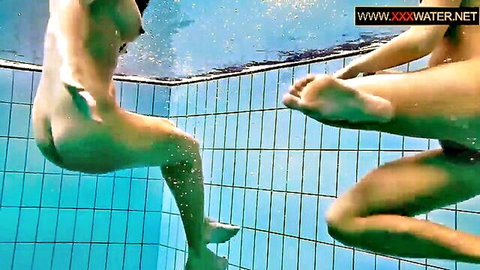 Two nude Russian lesbians embracing intimately underwater in pool