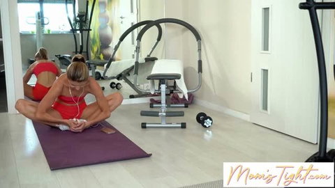 Gina Gerson in red workout outfit doing yoga stretches on purple mat