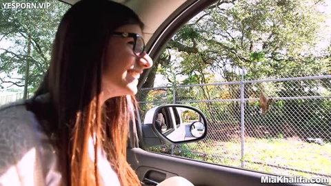 Mia Khalifa smiling in car with outdoor view