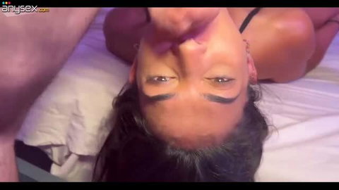 Latina woman upside down on bed getting facial from boyfriend