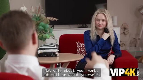Stanley Johnson interview with blonde woman in blue blouse on red couch