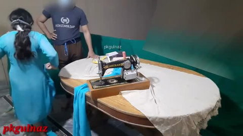 Indian desi girl in blue dress with tailor in sewing room