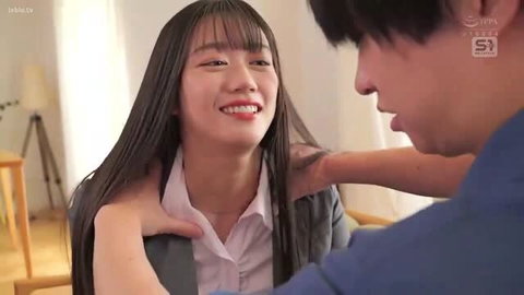 Smiling Japanese woman in office attire with man touching her shoulder