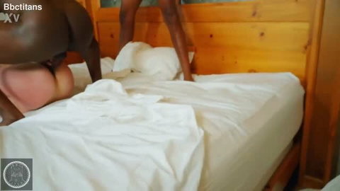Black couple in doggystyle on wooden bed, interracial sex scene