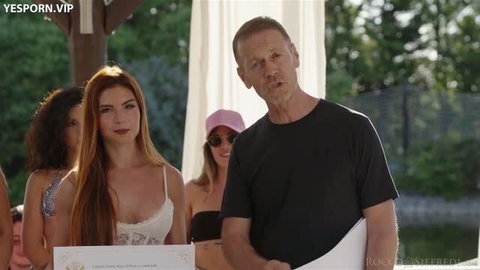 Rocco Siffredi with redhead model holding certificate in outdoor setting