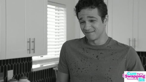 Young man in kitchen with wet t-shirt, Cum Swapping Sis logo visible