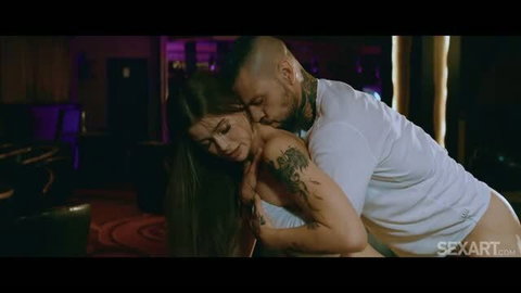 Olivia Sparkle in passionate couple scene, white tank top, tattooed man embracing her