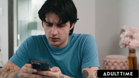 Suspicious tattooed guy checking phone with shocked expression