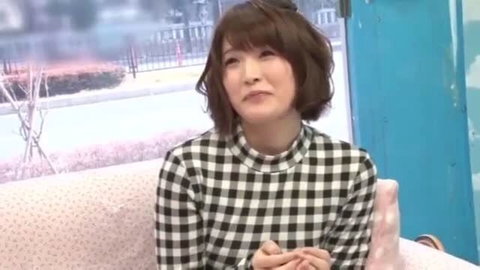 Japanese woman in checkered top sitting on couch