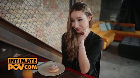 Lula Stocch in black satin robe posing at table with donut