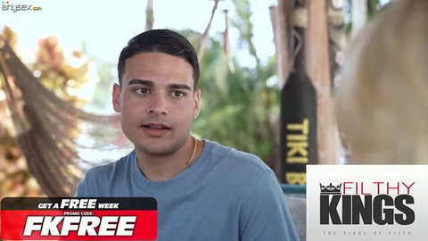 Young Latino man in blue t-shirt looking at camera, outdoor setting