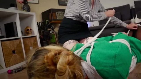 Lesbian bondage with woman tied in green sweater and white rope