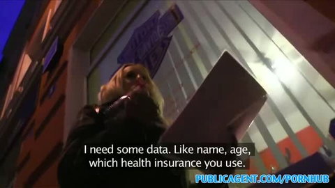Blonde woman outdoors at night holding phone to ear, PublicAgent watermark